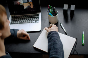 Student Workspace A student working at a table with a laptop, pencils and a notebook.